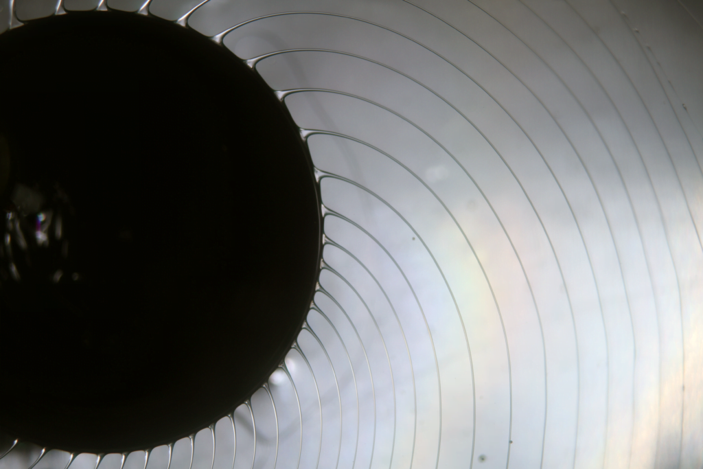 A wider view of silicone oil ligaments spinning off a rotary atomizer.