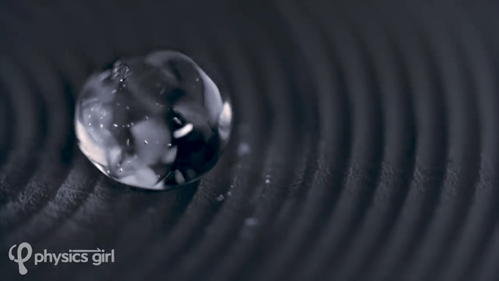 A Leidenfrost droplet hovering over a grooved surface bounces and ripples.