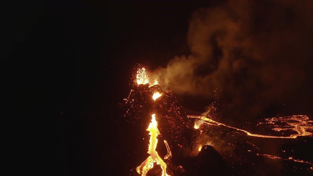 Lava erupts in fountains against the night sky.
