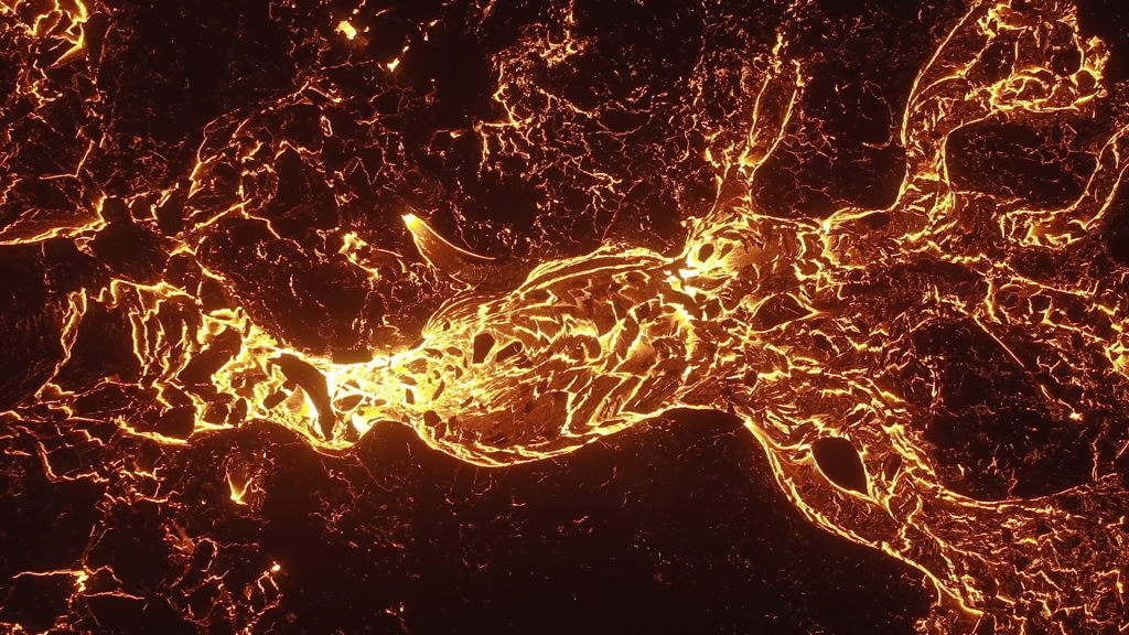 Hardened blocks of lava flow on a molten river.