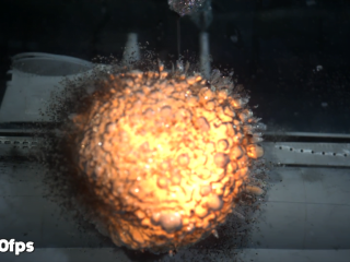 A halo of unexploded powder breaks through the uneven surface of the explosion's bubble.
