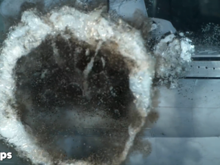 A bubbly vortex ring forms as the explosion hits the tank wall.