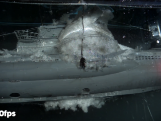 The expanding bubble surrounding exploding charges atop the sub model.