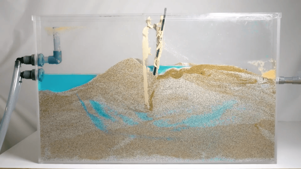 Model of a levee with an I-wall that's failed after subsurface water seepage weakened the structure.