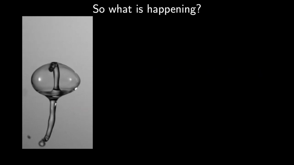 When the sides of the drop meet, capillary waves generate two Worthington jets, one of which the now-bubble eats.