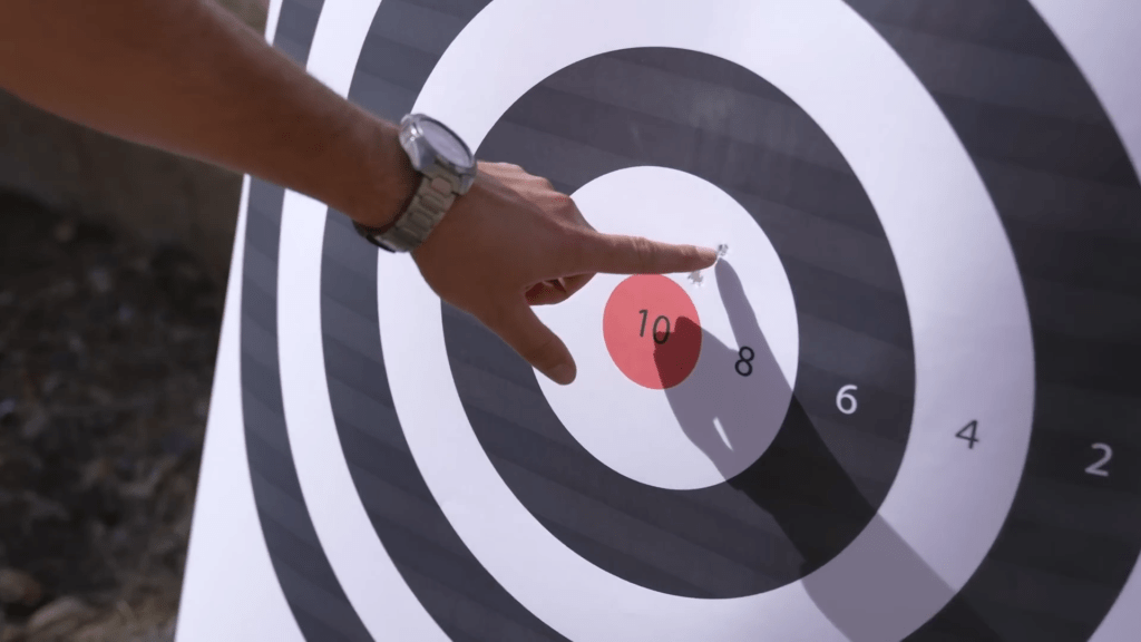 Examining the grouping of various shots fired. Examining the grouping of various shots fired.