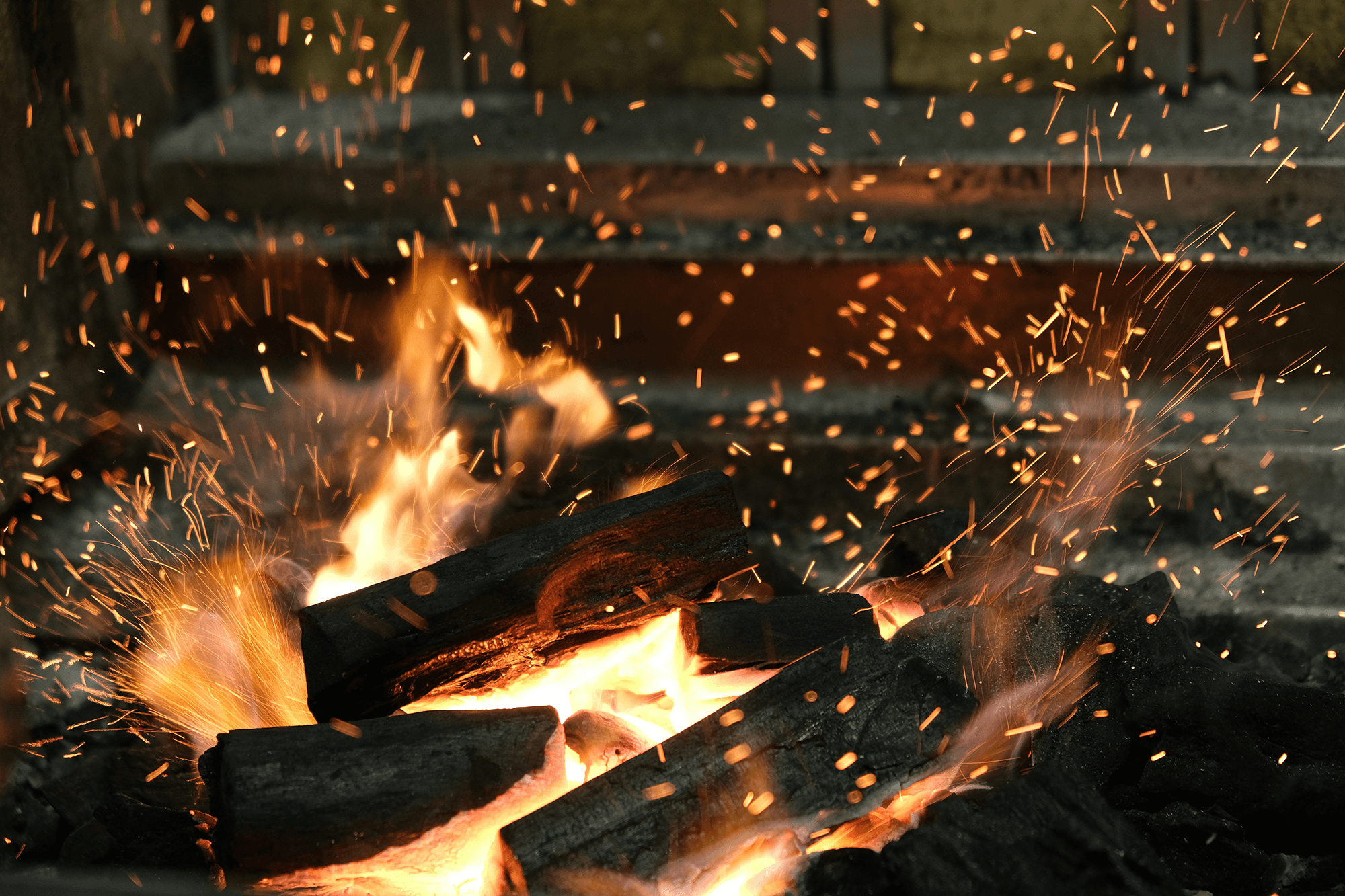 A close-up image of a fire with sparks.