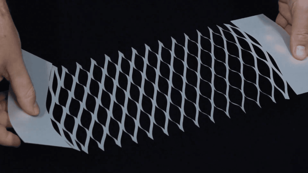 Cut patterns in a thin plastic sheet allow the sheet to expand when pulled. Cut patterns in a thin plastic sheet allow the sheet to expand when pulled.