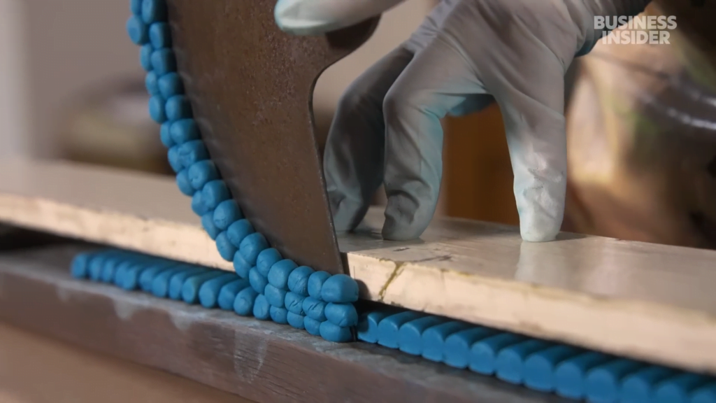 After hand-rolling each pastel, they trim the ends. After hand-rolling each pastel, they trim the ends.