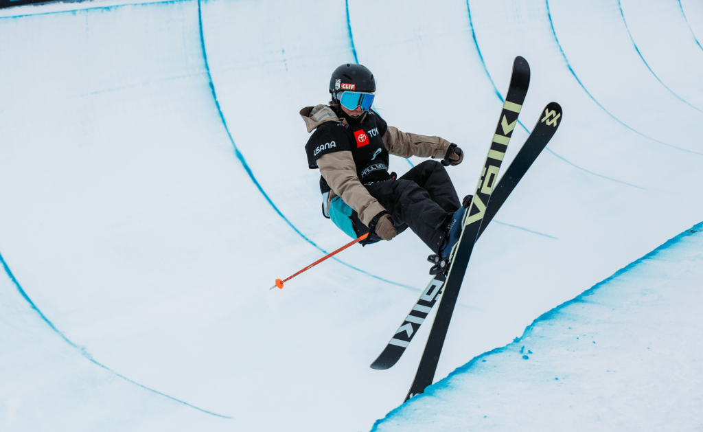 A skier competes in a halfpipe. A skier competes in a halfpipe.
