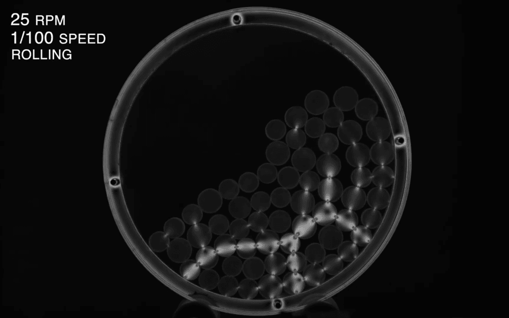 Black and white image of force chains in particles rolling in a drum.