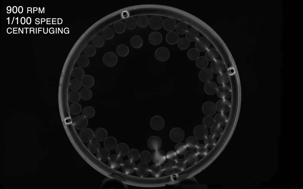 Black and white image of force chains in particles getting centrifuged in a drum.
