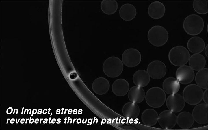 Animation of stress reverberating through particles as they roll in a drum.