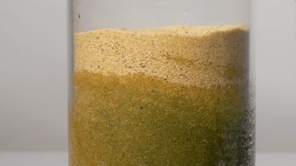 Water seeps up through sand in a glass container. Water seeps up through sand in a glass container.